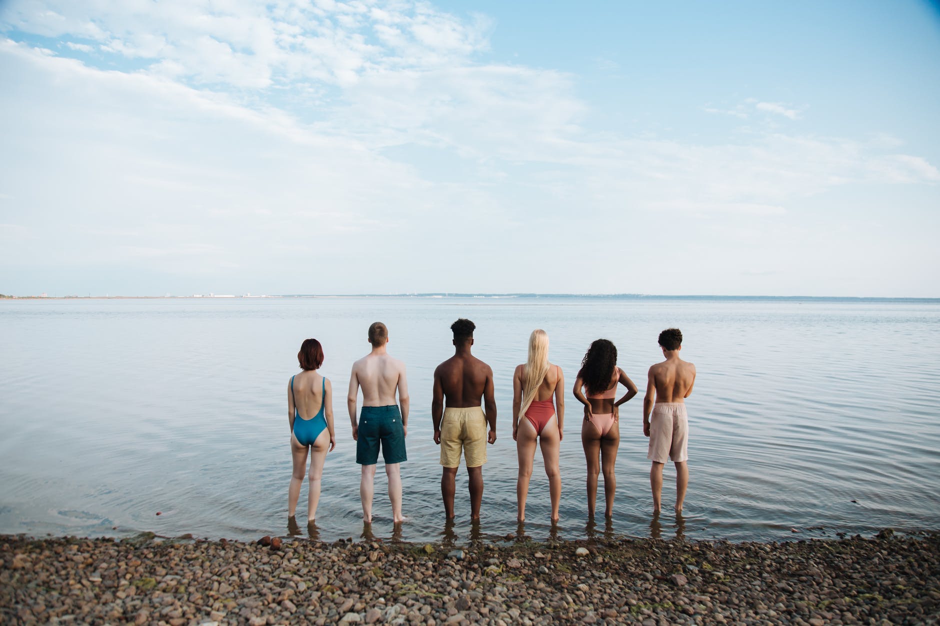 rear view of teenagers standing on beach